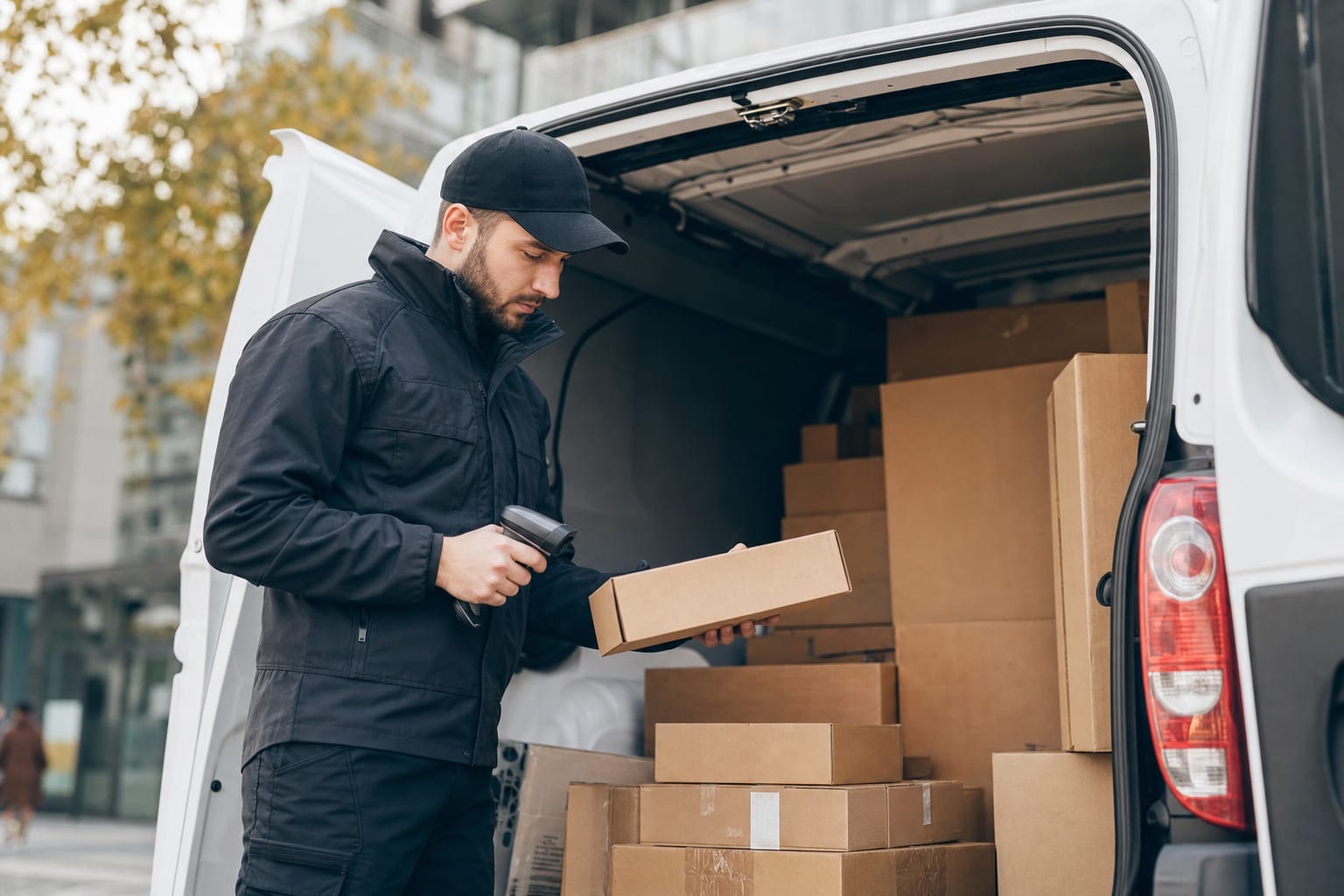 Delivery driver loading parcels into a vehicle